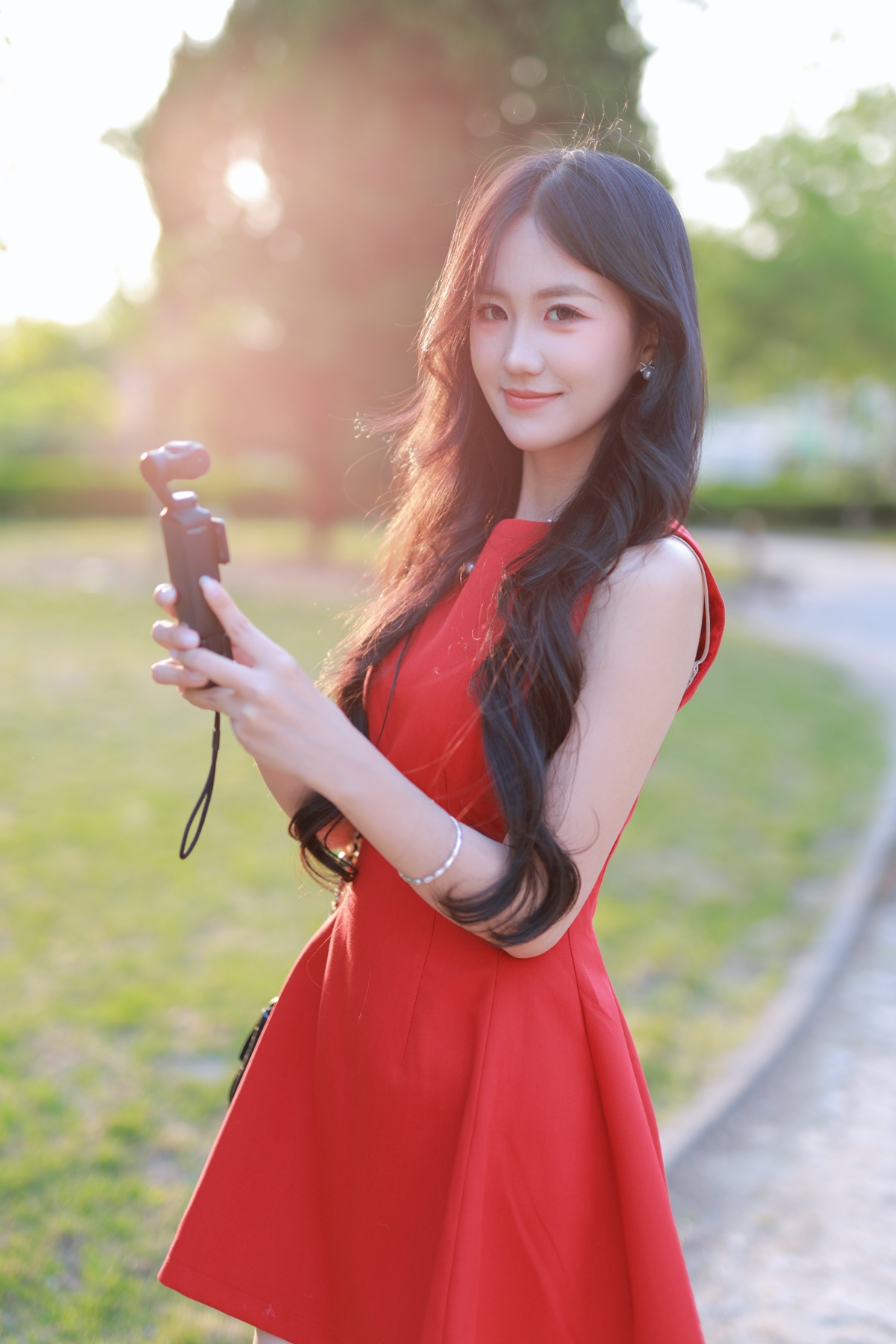 Xinyuan Shi holding a camera in warm evening light